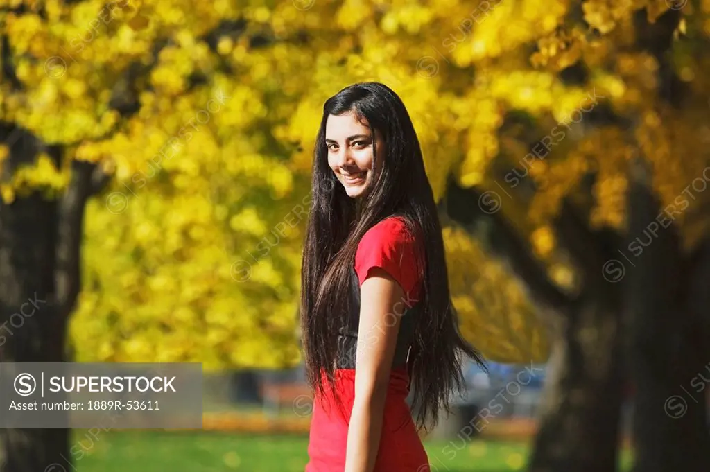 a teenage girl in a park in autumn