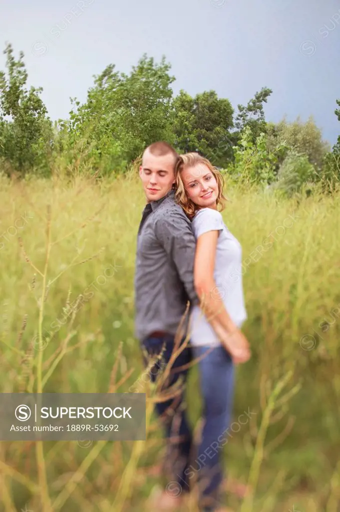 jordan, ontario, canada, a couple standing back to back in a field