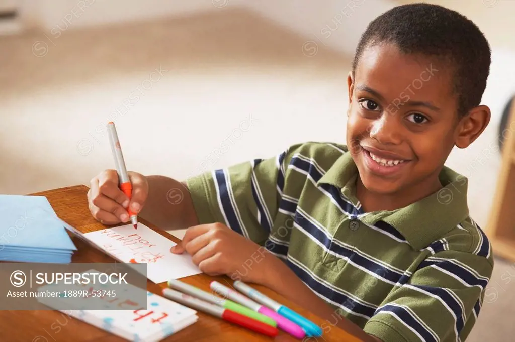 a boy writing thank you cards