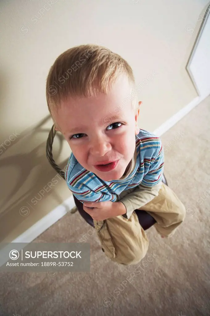 high angle of a boy sitting in a chair