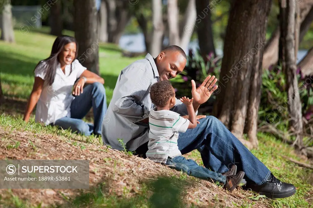 fort lauderdale, florida, united states of america, a father plays with his young son while the mother is watching