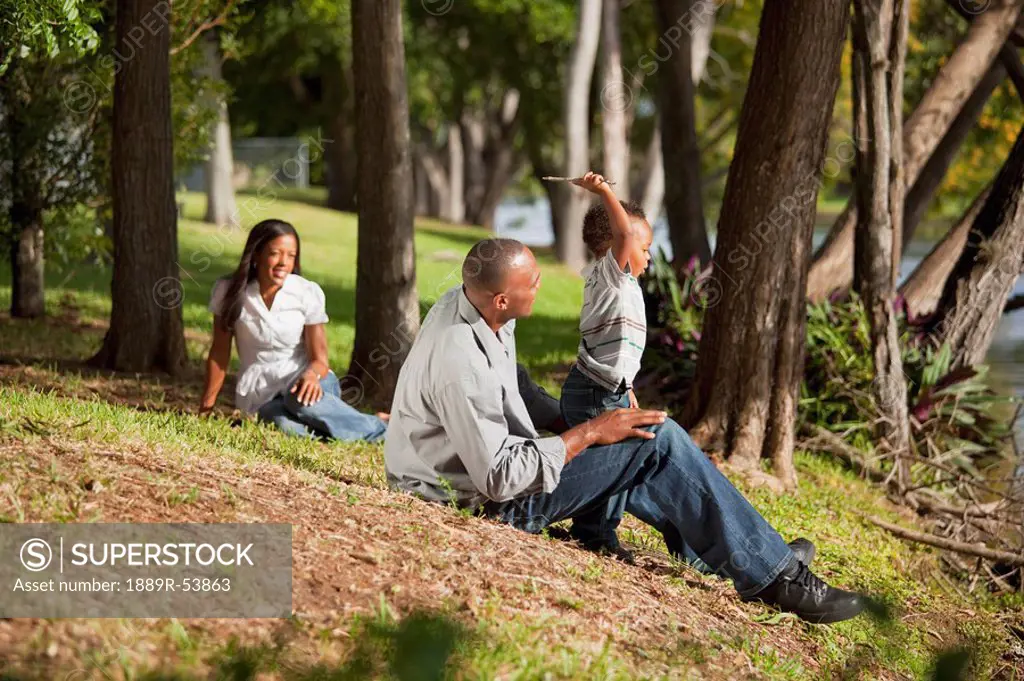 fort lauderdale, florida, united states of america, a father plays with his young son in a park while the mother is watching