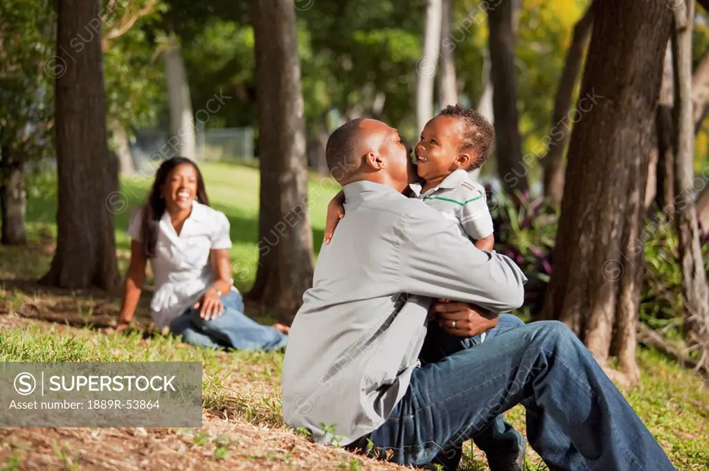 fort lauderdale, florida, united states of america, a father and young son hug while the mother watches