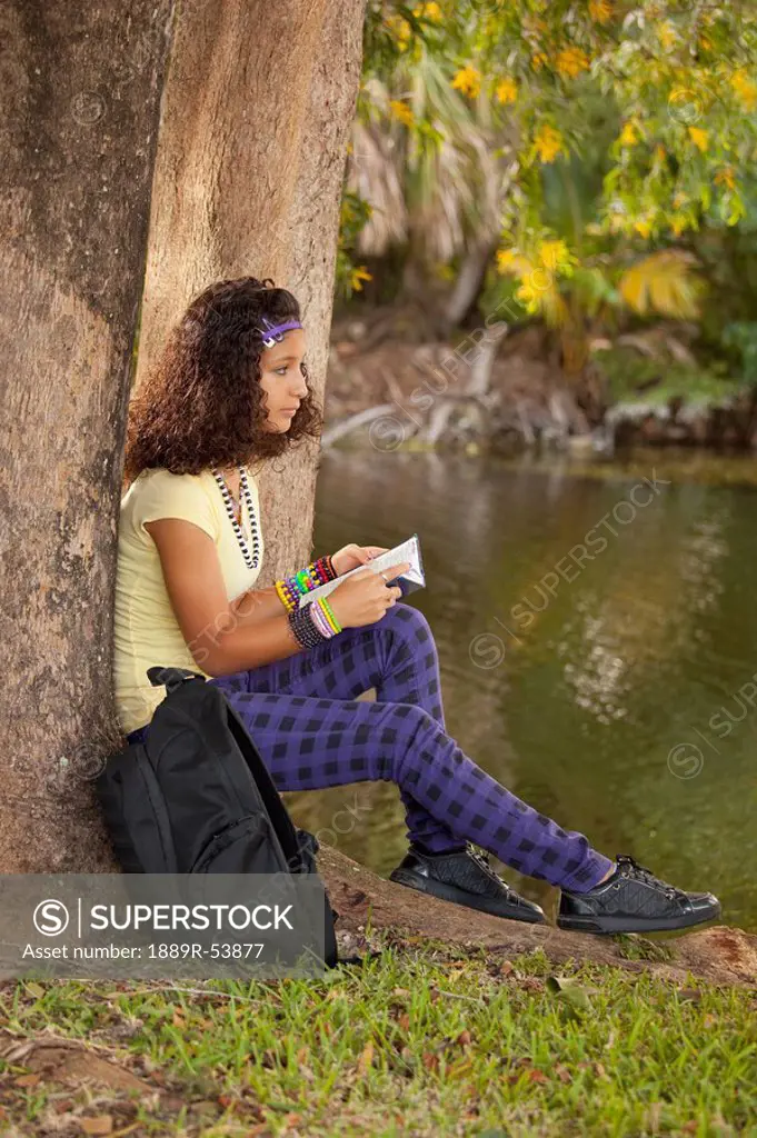 fort lauderdale, florida, united states of america, a girl reading a book under a tree