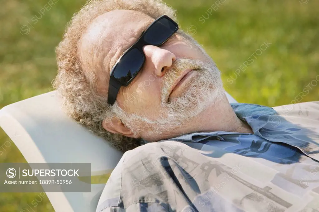 sherwood park, alberta, canada, a man laying in a lawn chair wearing sunglasses