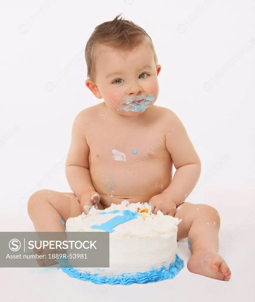 edmonton, alberta, canada, a baby eating birthday cake with his hands