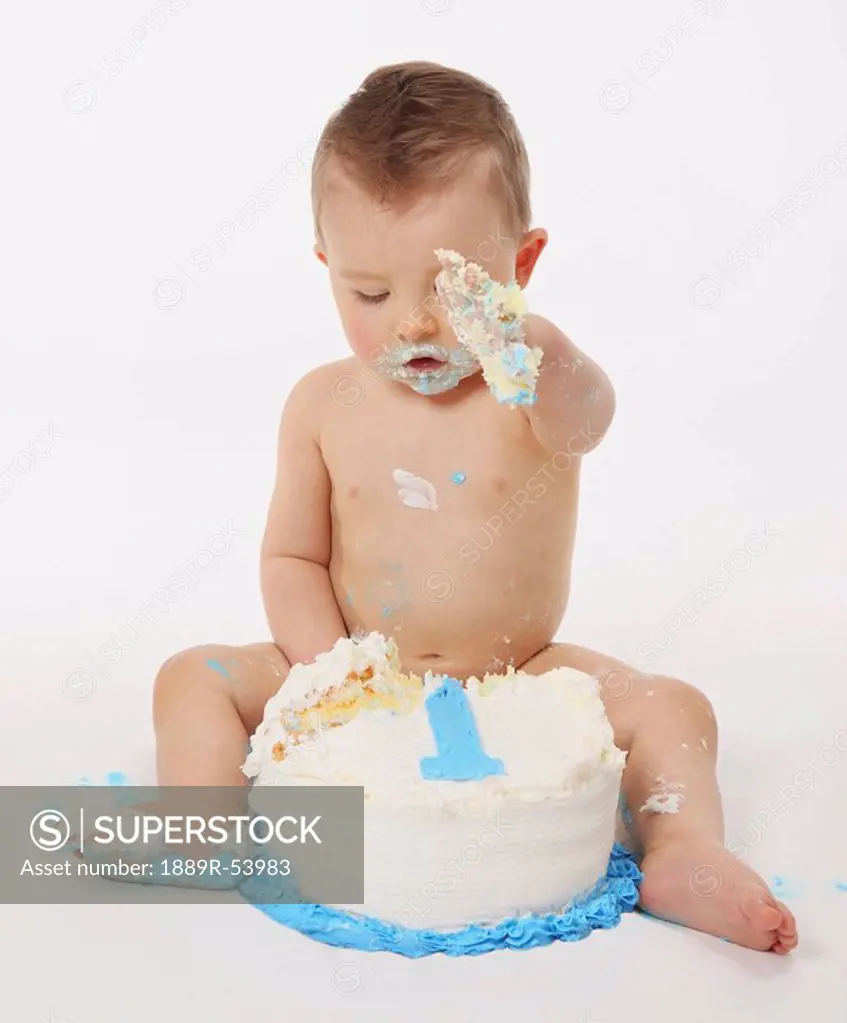 edmonton, alberta, canada, a baby eating a birthday cake with his hands