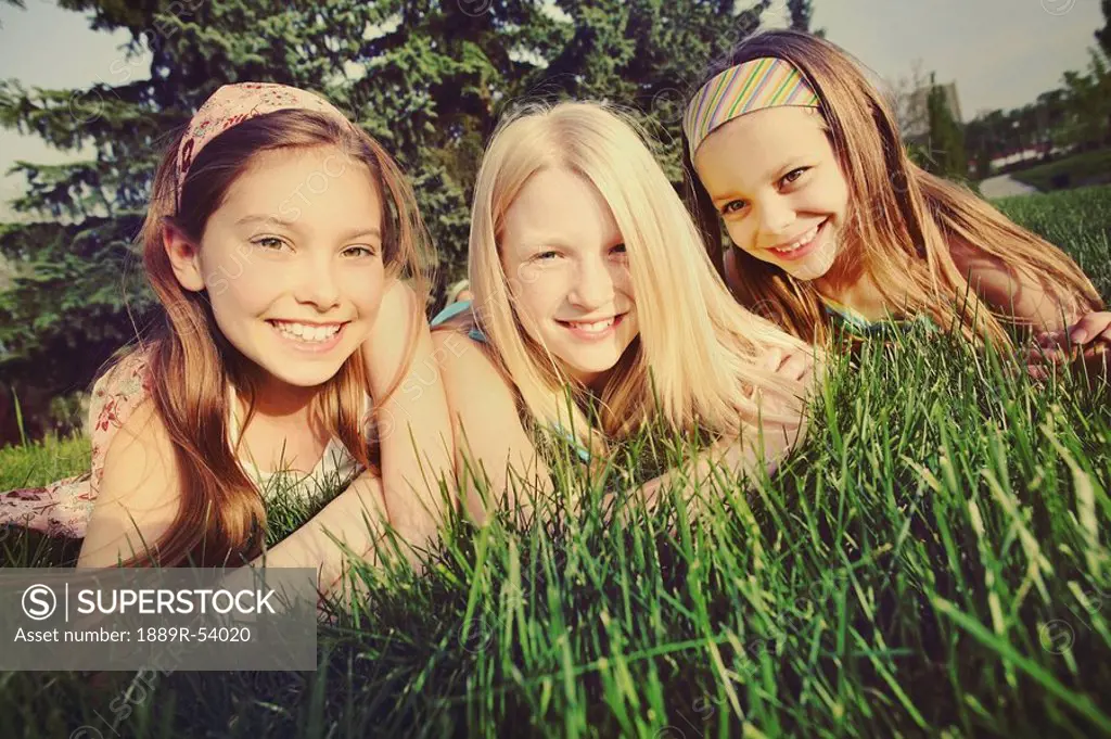 edmonton, alberta, canada, three girls laying on the grass