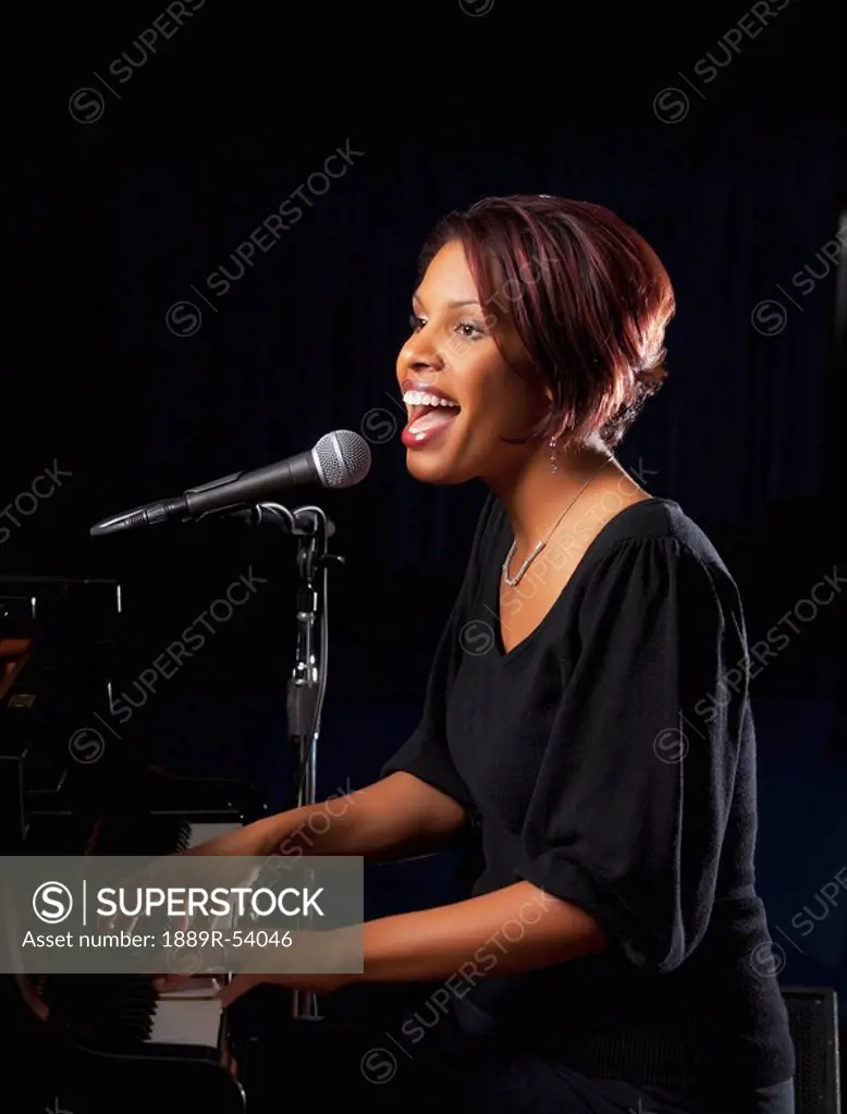 fort lauderdale, florida, united states of america, a woman playing the piano and singing into a microphone