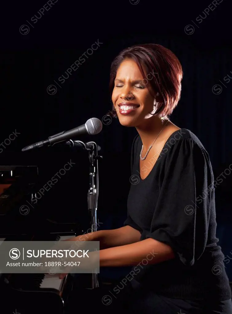 fort lauderdale, florida, united states of america, a woman singing into a microphone and playing the piano
