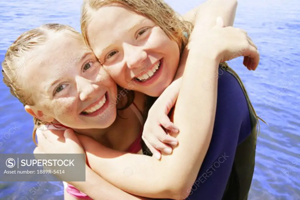 Two girls hug in the water