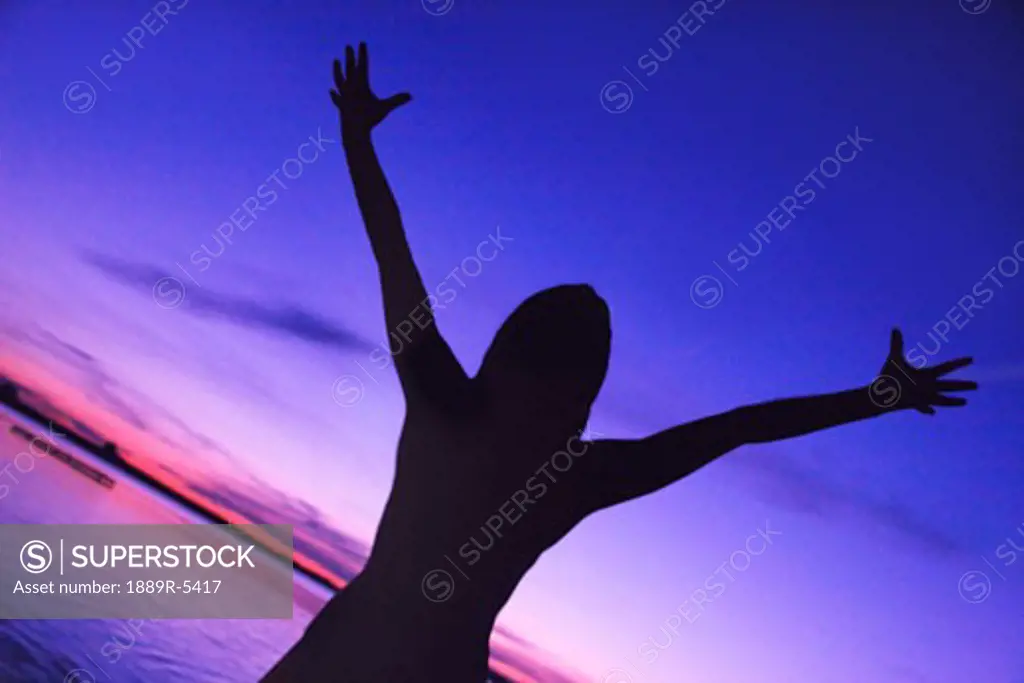 Silhouette of woman with arms raised