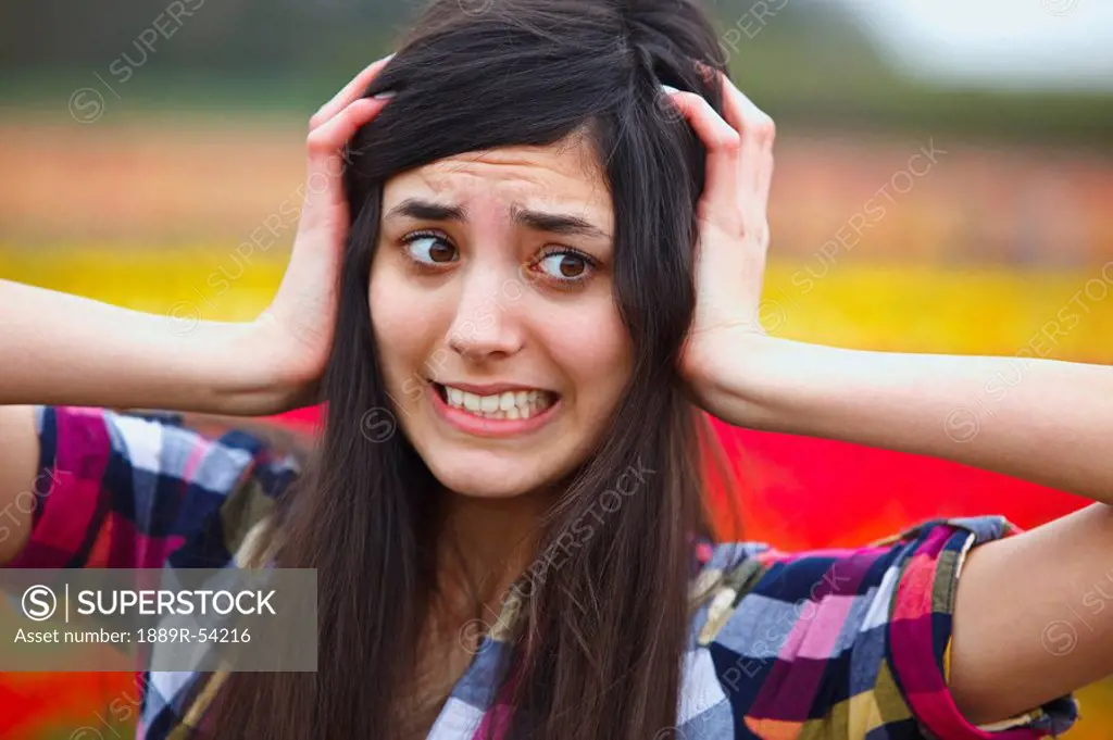 a girl holding her head with a crazy face