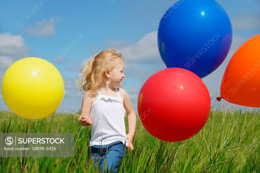 A child holding colorful balloons