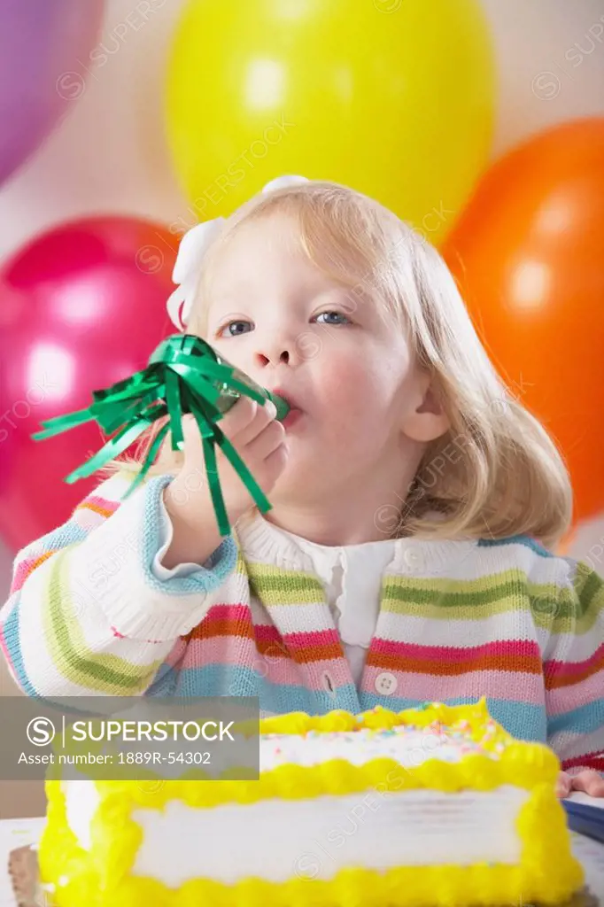 Knoxville, Tennessee, United States Of America, A Young Girl With Balloons And A Cake And Blowing Into A Party Blower