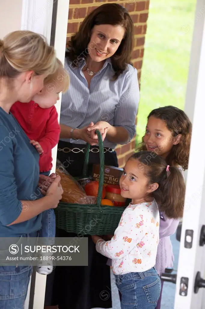 Knoxville, Tennessee, United States Of America, A Woman With Her Two Daughters Delivering Food In A Basket To A Woman With Her Child