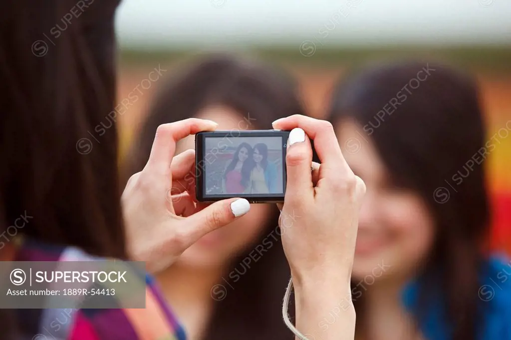 a girl taking a picture of her two friends