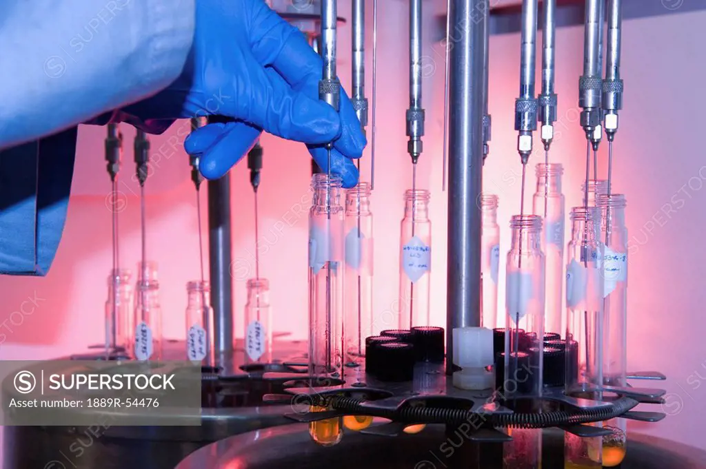edmonton, alberta, canada, a gloved hand puts liquid into test tubes in a labaratory