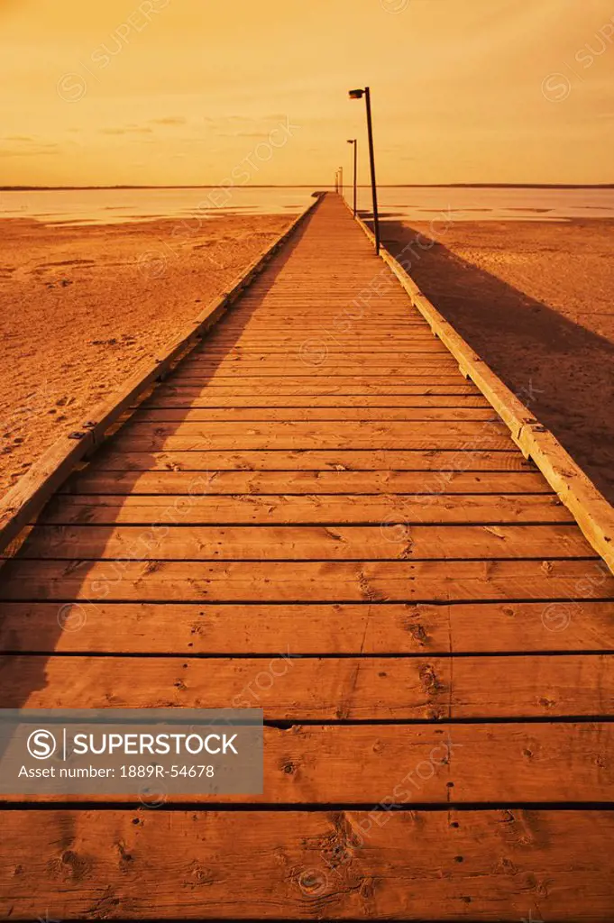 Alberta, Canada, A Pier On The Sand Leading Out To The Lake