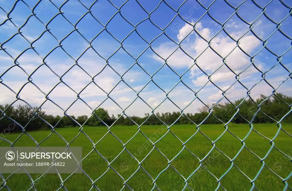Alberta, Canada, Looking At The Sky Through A Chain Link Fence