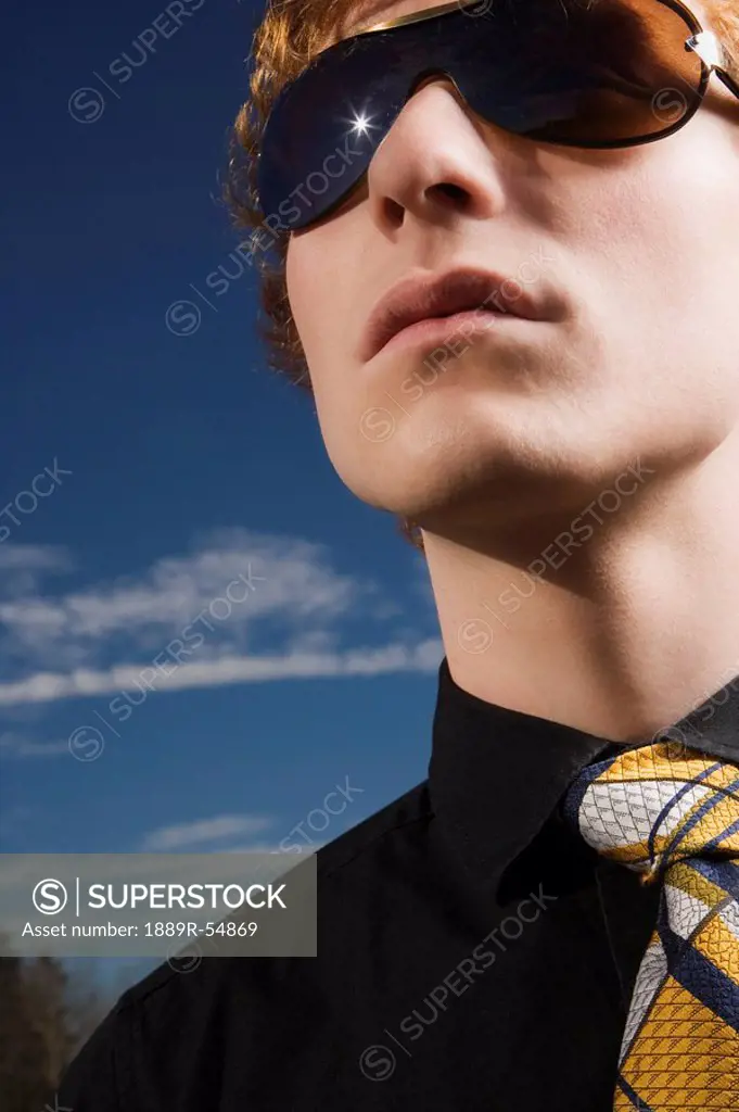A Young Man Wearing Sunglasses And A Necktie