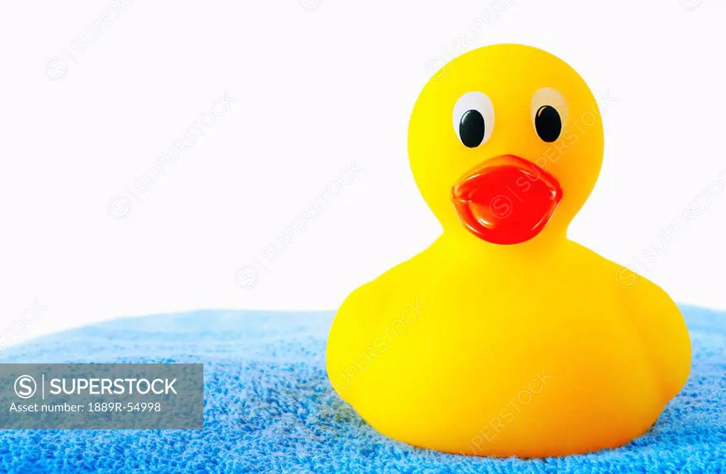 A Rubber Duck Sitting On A Blue Bath Towel