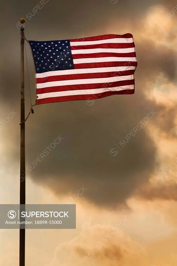 The American Flag Flying In A Cloudy Sky