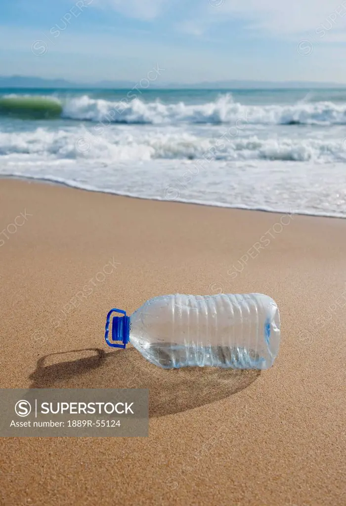tarifa, costa de la luz, cadiz, andalusia, spain, an empty plastic water bottle on bunker beach