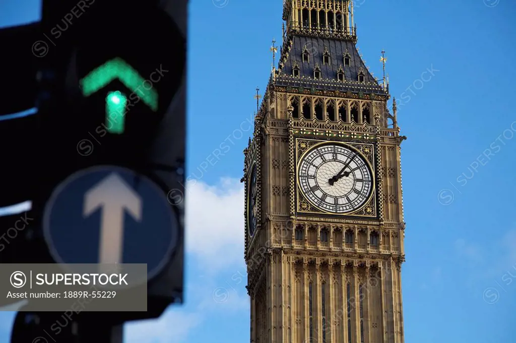 a clock tower with a green arrow showing on a traffic light