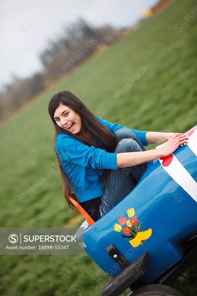 woodburn, oregon, united states of america, a girl sitting in a painted wooden shoe at the wooden shoe tulip farm