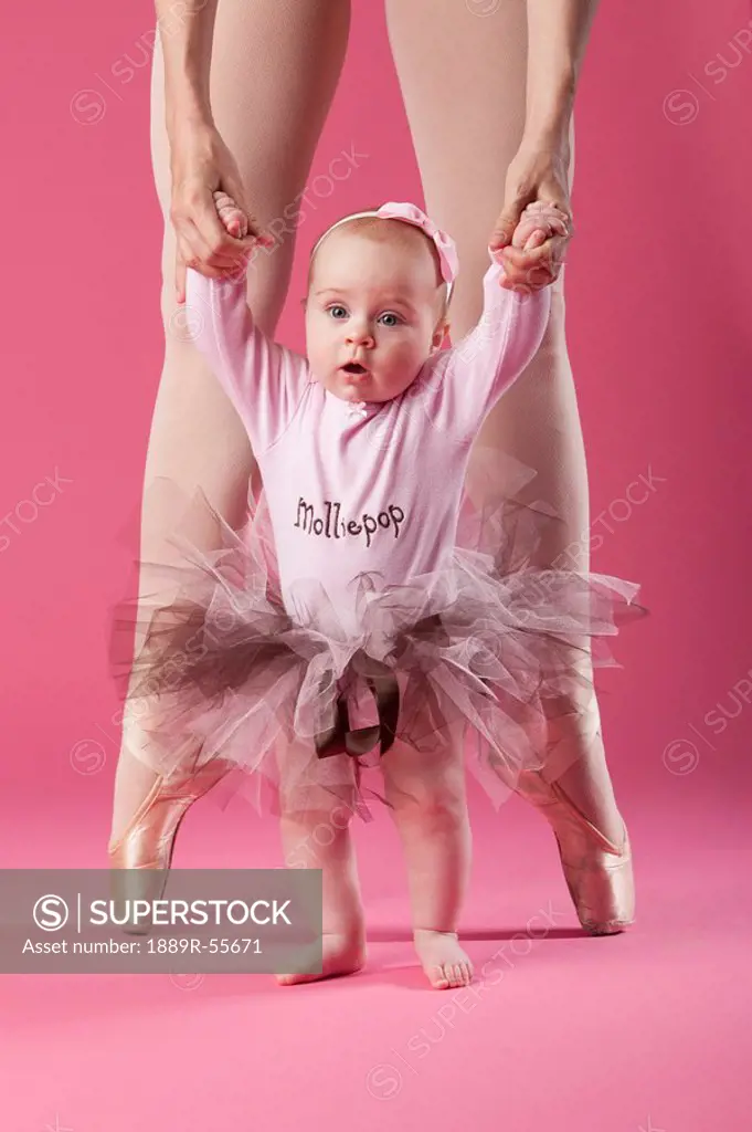 baby girl in tutu with ballerina in pointe shoes