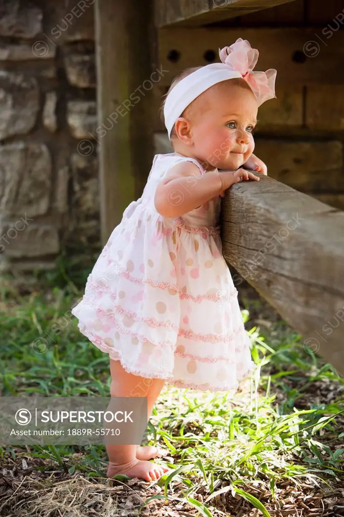 baby girl standing against a fence, nashville, tennessee, united states of america