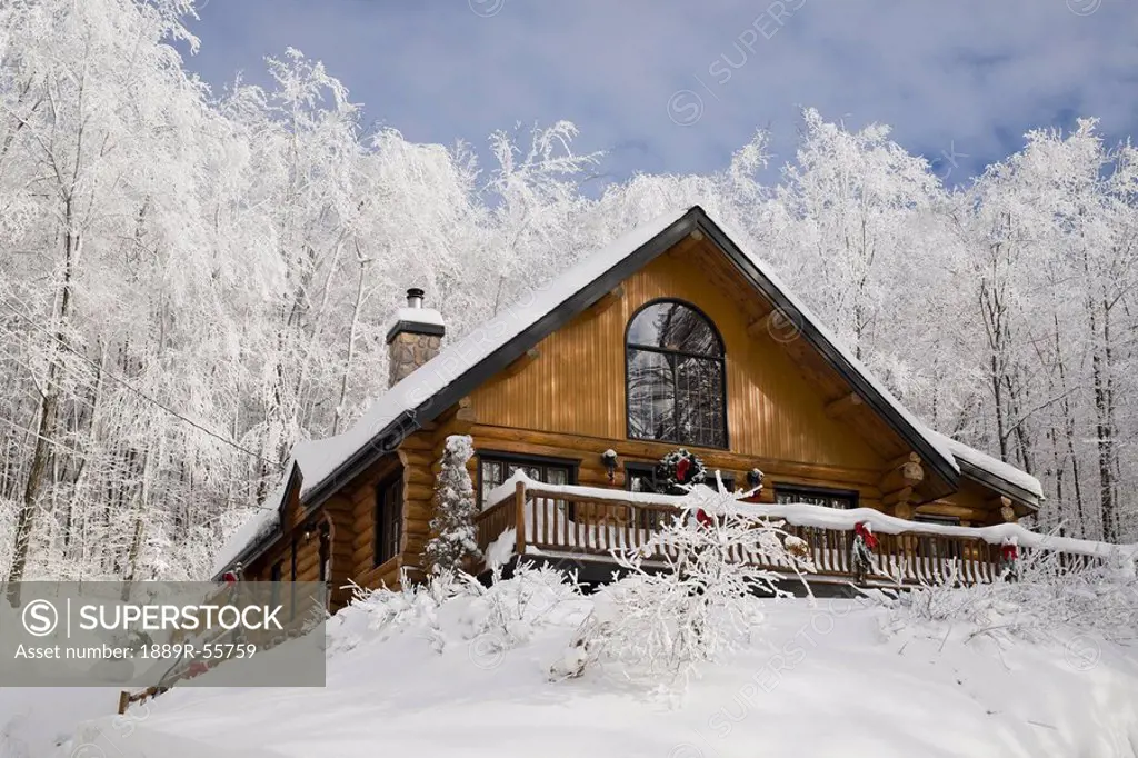 log house in the winter, quebec, canada