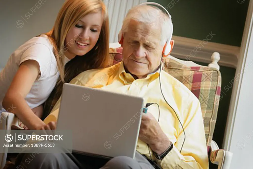 Teen shows senior how to use computer