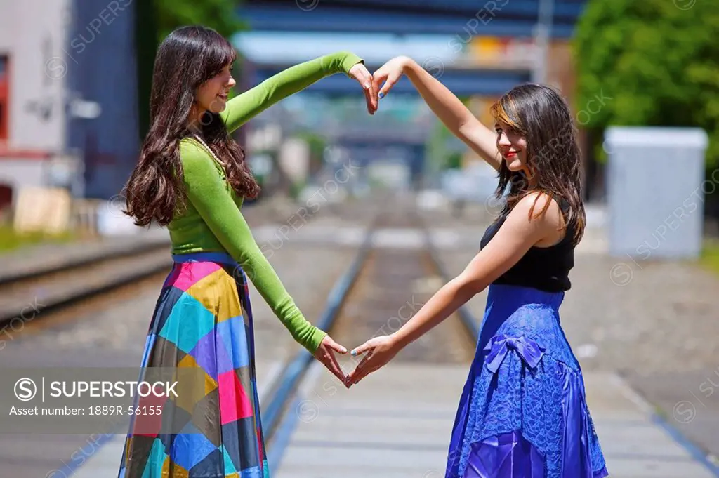 teenage girls forming a heart with their arms, portland, oregon, united states of america