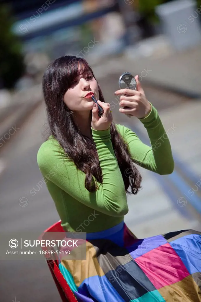 teenage girl applying lipstick, portland, oregon, united states of america