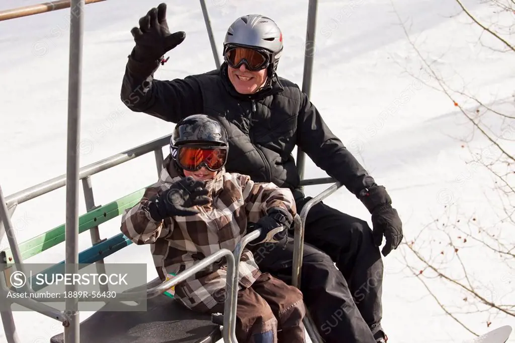 red deer, alberta, canada, a father and son on a chair lift at a ski area