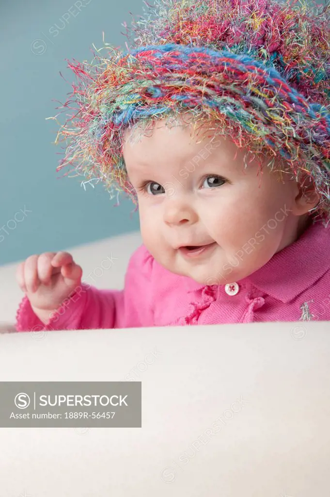 a baby girl wearing a colorful hat