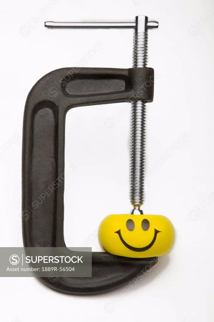 yellow happy face squeezed by a clamp, edmonton, alberta, canada