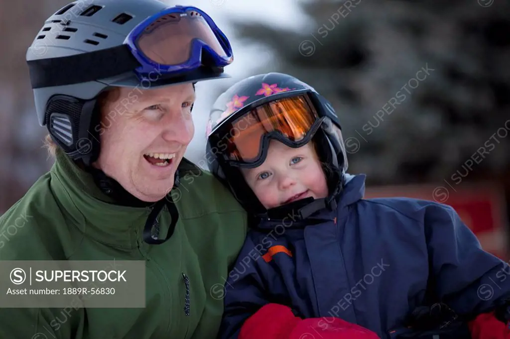 red deer, alberta, canada, a father and young son wearing helmets and ski masks