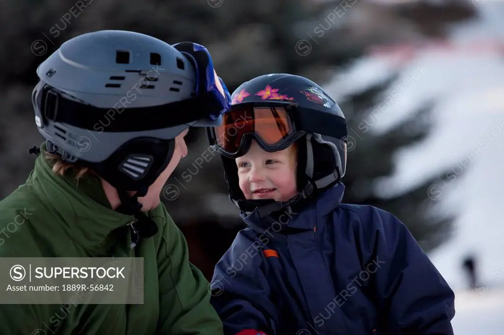 red deer, alberta, canada, a father and son wearing helmets and ski masks at a ski area