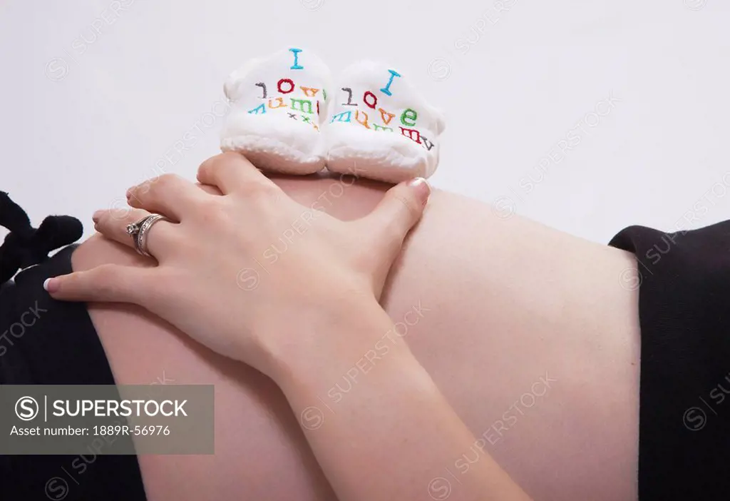 pregnant woman with ´i love mummy´ booties on her bare belly