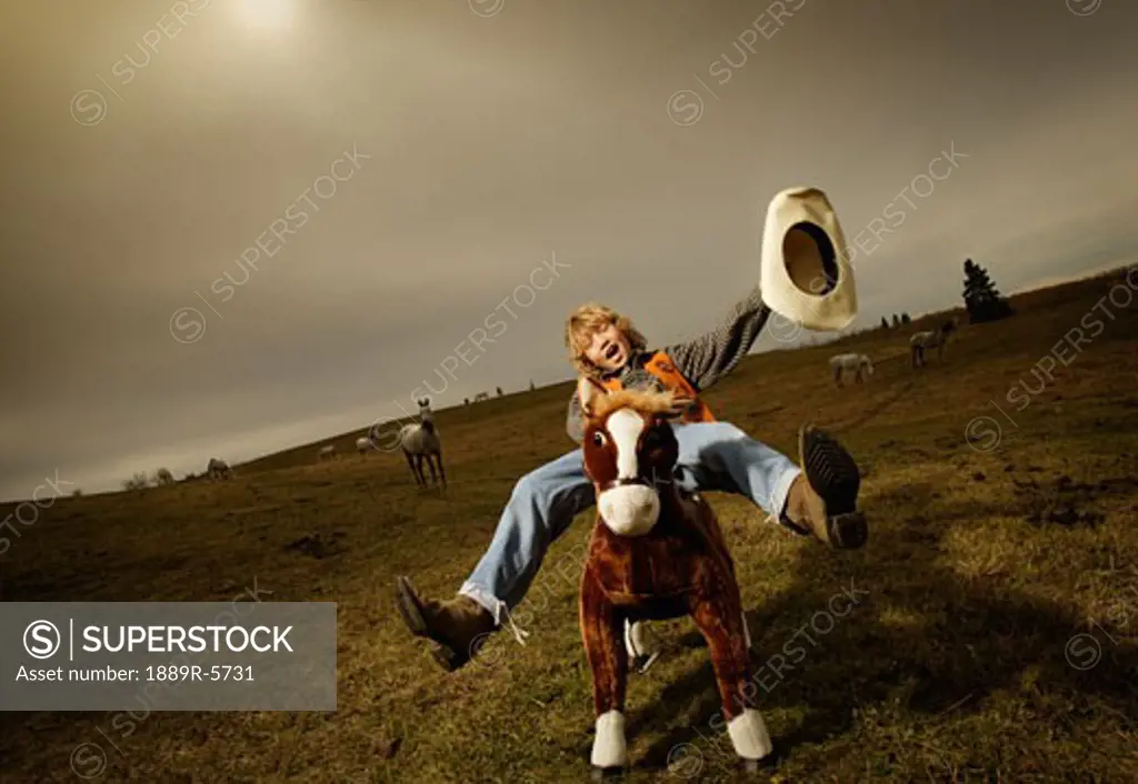Teenage cowboy on stuffed horse