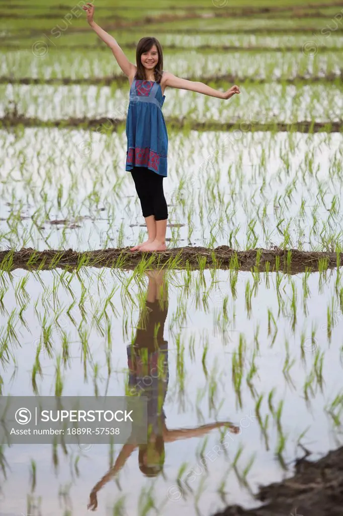 a teenage girl standing in a rice field, chiang mai, thailand