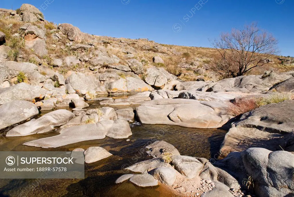 stream surrounded by a rocky, dry terrain, cordoba, argentina