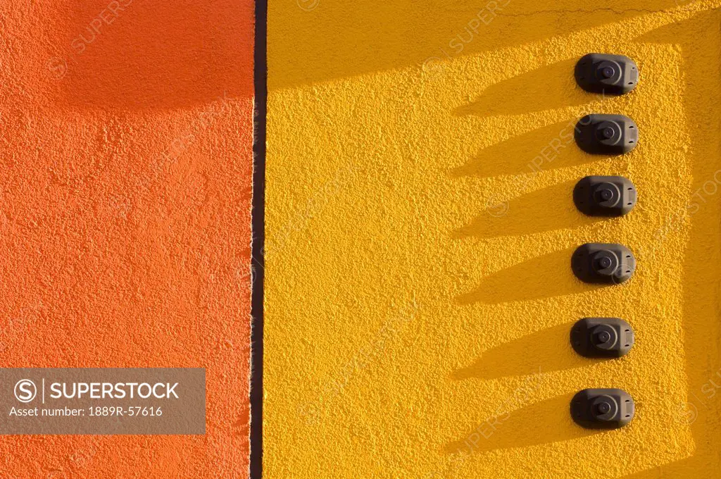 orange and yellow stucco wall with 6 doorbells, st. albert, alberta, canada