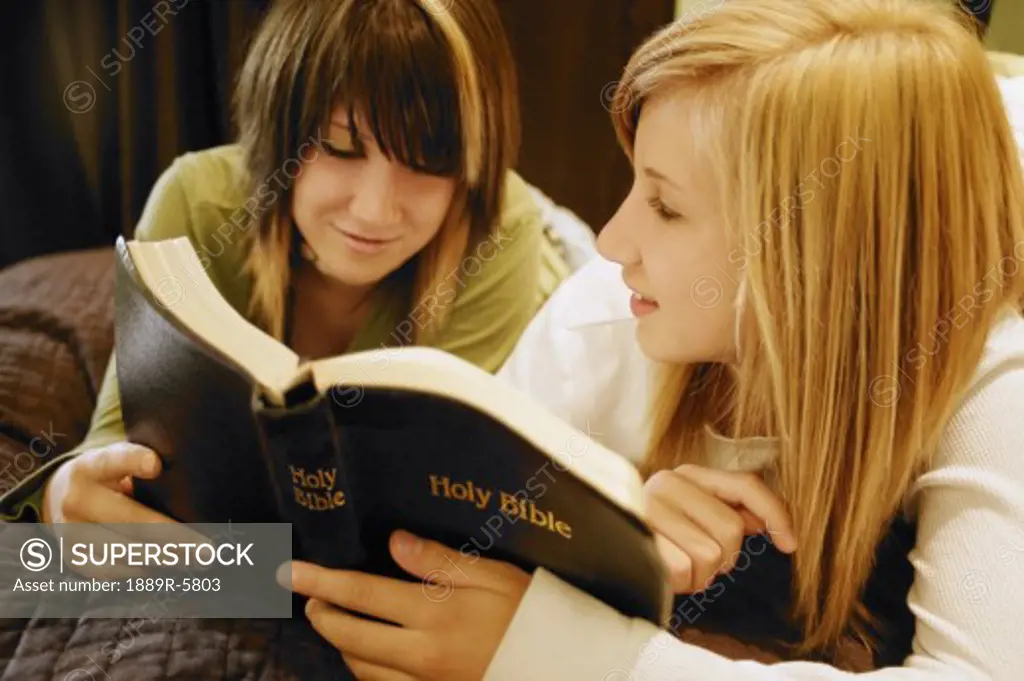 Two teens reading a Bible
