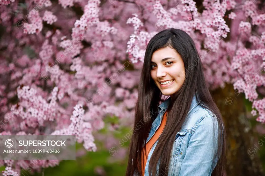 Portland, Oregon, United States Of America, A Teenage Girl By A Tree Full Of Blossoms In Portland Park