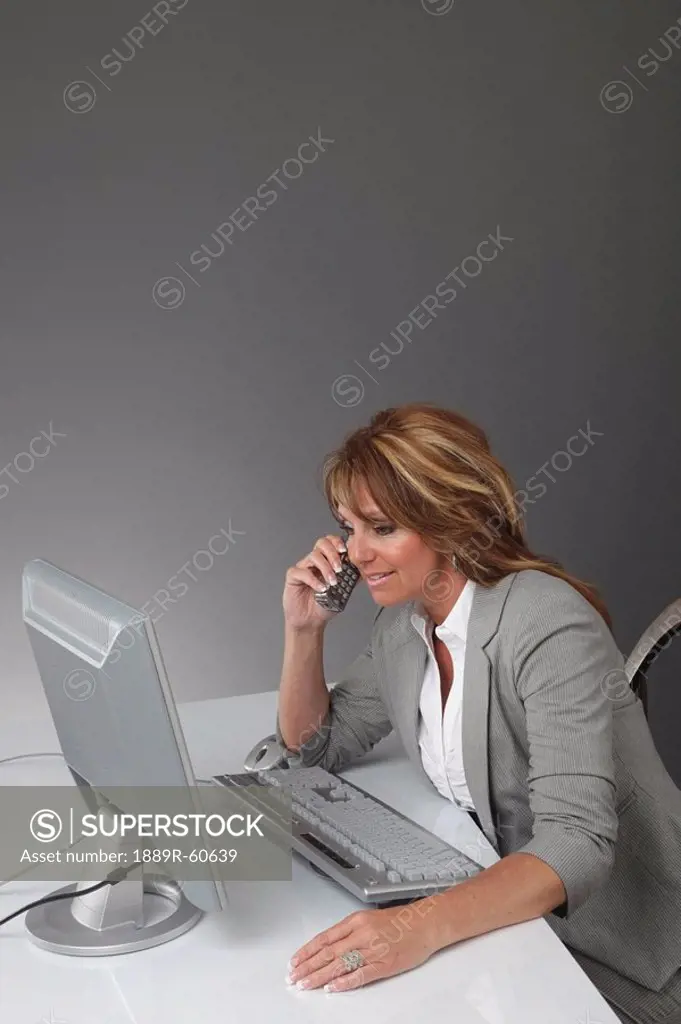 Jordan, Ontario, Canada, A Businesswoman Working At A Desk With A Computer And Talking On The Phone