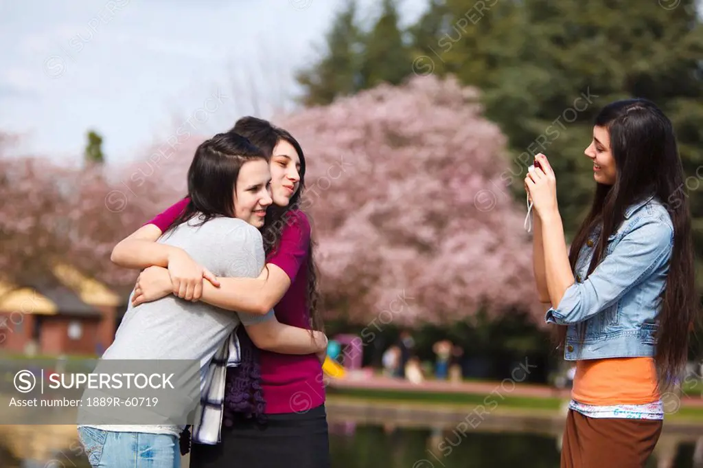 Portland, Oregon, United States Of America, Three Teenage Girls Using A Camera In Portland Park